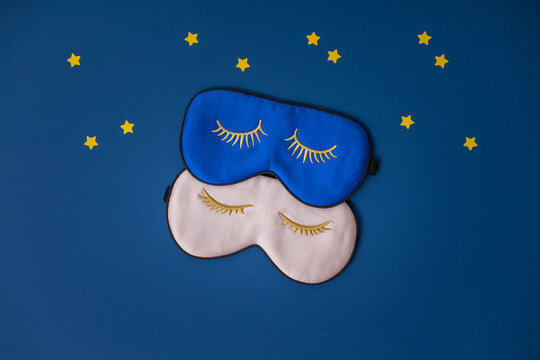 Two sleeping masks and paper stars on blue background, concept of rest, quality of sleep, good night, insomnia, relaxation