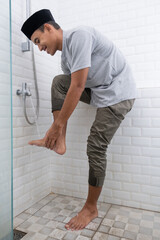 portrait of young Muslim man perform ablution (wudhu) before prayer at home