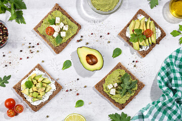 Flat lay composition of avocado toast on light  base. Vertical format.