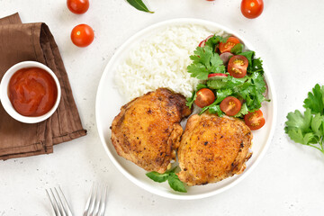 Fried chicken thighs with vegetables and rice in plate