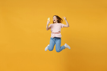 Full length of young expressive friendly overjoyed woman 20s in basic pastel pink t-shirt jump high...