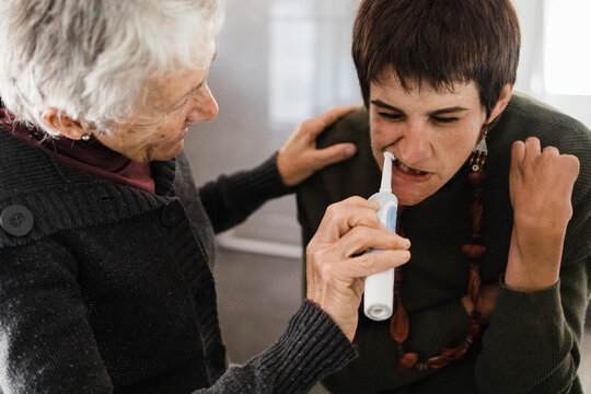 Mother brushes daughters teeth