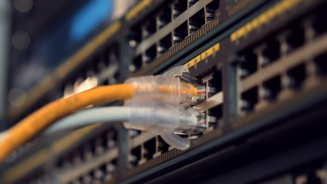 IT Engineer Patching Network Equipment In Server Room.Network Engineer Maintenance Work In Server Room .IT Technician Works With Ware And Cables in Big Data Center.Connecting Lan Cable To Mainframe