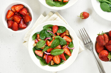Salad with strawberry, red onion and spinach in white bowl
