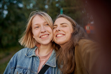 two girls take selfies on their smartphone while traveling
