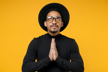 Young trustful pleaded african american man in stylish black hat shirt eyeglasses tattoo translate...