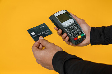 Closeup cropped photo shot dark-skinned man black shirt hold in hand wireless modern bank payment...