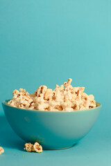 Bright pictures of popcorn. Popcorn in a blue plate. Blue background. Flat lay, copy space. Banner