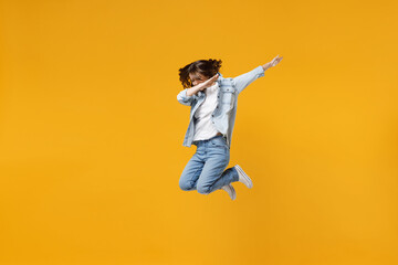 Fototapeta na wymiar Full length of young overjoyed fun woman 20s wear denim shirt white t-shirt doing dab hip hop dance hands move gesture youth sign hiding covering face isolated on yellow background studio portrait