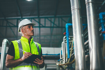 Portrait of engineer foreman writing on digital tablet and checking in industrial factory. worker...