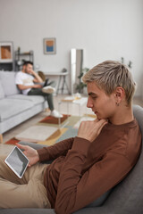 Young Man Watching Videos via Tablet at Home