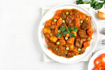 Beef stew with potatoes and carrots in tomato sauce