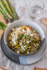 healthy barley soup with spring vegetables, asparagus, wild garlic and carrots