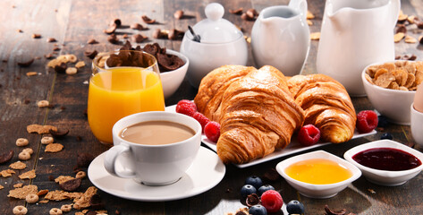 Fototapeta na wymiar Breakfast served with coffee, juice, croissants and fruits