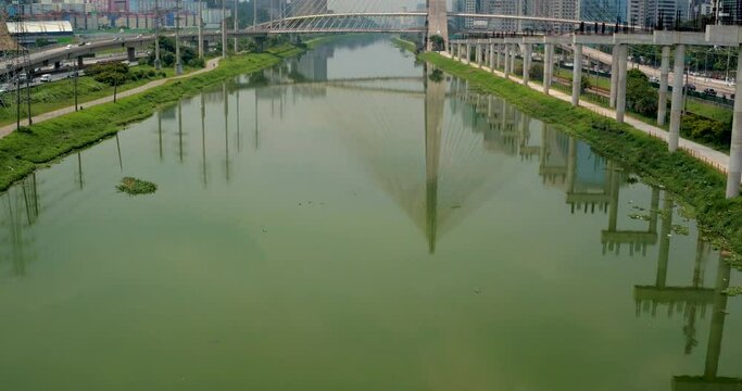 Cinematic establishing aerial shot of the Ponte Estaiada Bridge in Sao Paulo, Brazil. Tilt up reveal shot, slow push in.