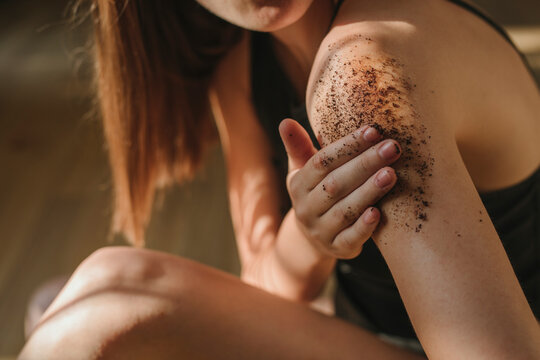 Woman applying coffee scrub
