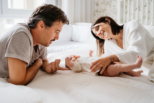 Young parents with baby at bed