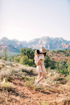 Mom carrying daughter on back while hiking