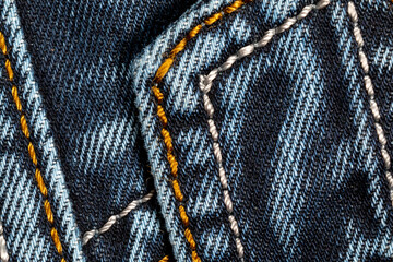 Jeans background. Denim fabric with seams close-up.