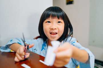 Little girl cutting paper with scissors