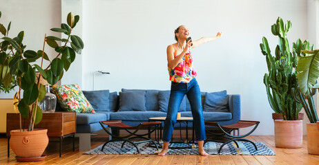 Positive woman with smartphone dancing at home