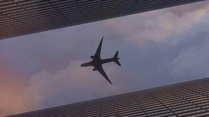 Fototapeta na wymiar Airplane flying over the top big city skyscraper office buildings. 3d rendering