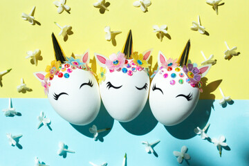 Easter eggs in the form of a unicorn with white delicate flowers. The minimum concept of Easter.