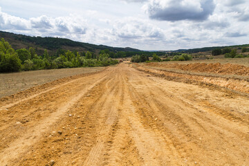 Desmonte, explanacion, nivelacion  y desbroce de vegetacion en terrenos de campo para la construcción de camino o carretera