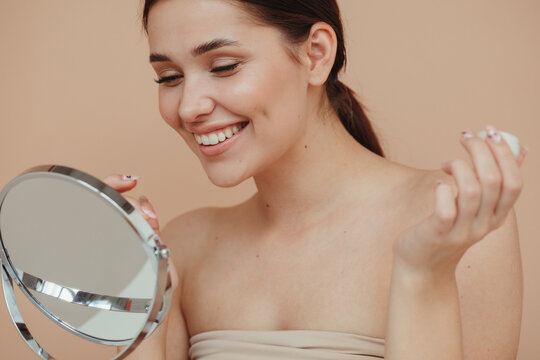 Cheerful model looking at mirror