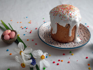 Stylish easter eggs natural dyed and homemade easter cake on rustic cloth with flowers on wooden table. Happy Easter. Traditional Easter food.