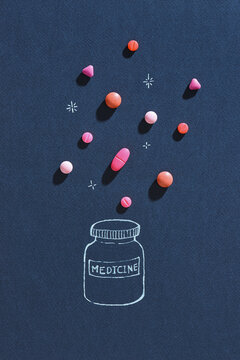 Scattered red and pink pills with pillbox. medical concept