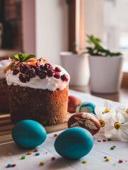 Stylish easter eggs natural dyed and homemade easter cake on rustic cloth with flowers on wooden table. Happy Easter. Traditional Easter food.