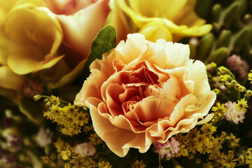 Nahaufnahme einer gelben Rose, aus einem Strauß voller Rosen.