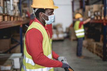 African warehouse worker man wearing safety face mask for coronavirus outbreak - Industiral...