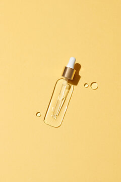 Cosmetic hydrating serum in a glass bottle with pipette close up. Hyaluronic acid on the blue background top view