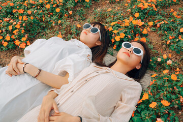Two young women lying in flowers enjoying the sun