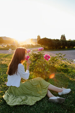 Young woman smelling flowers in park