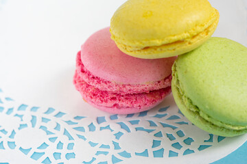 Colorful almond macarons on white napkin on blue background. French meringue cookies