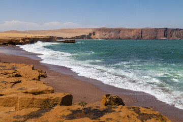 Fototapeta na wymiar Landscape photography of dunes and cliffs on the coast of the Paracas desert, Playa Roja, in the Paracas National Reserve, Pacific ocean, Pisco, department of Ica, Peru.