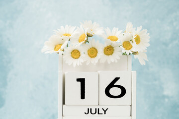 White cube calendar for july decorated with daisy flowers