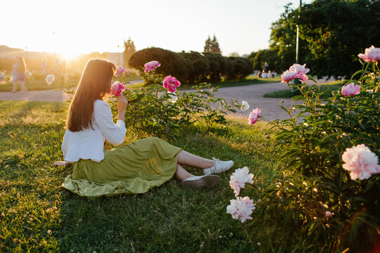 Young woman smelling flowers in park