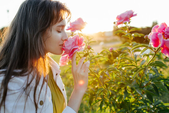Young woman smelling flowers in park