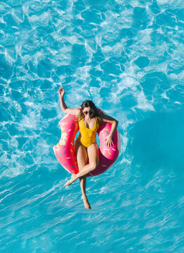 Woman in the water in a swimming pool on top of a float