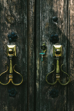 Old wooden door with golden knocker and cross with jesus
