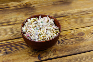 Tasty salad of grated celery root, mushrooms, onions on wooden table