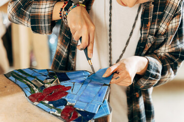 Skilful designer making panno or mosaics while working with the glass