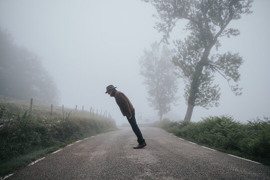 tree and lone man leaning in different directions