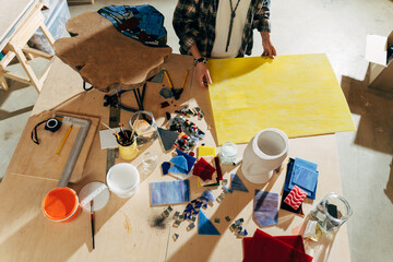 Artist breaks the glass with her hands while making mosaics at her studio