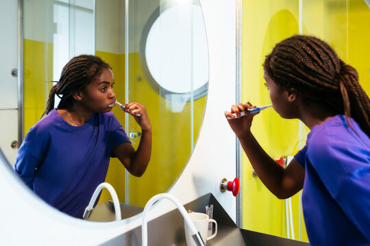 Black teenager brushing teeth in morning