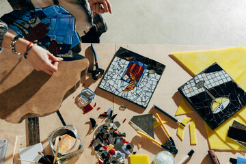 Designer working of new mosaics while spending time at her modern studio